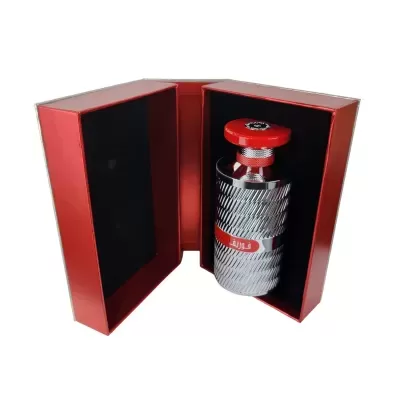 Frasco metálico prateado com tampa vermelha numa caixa vermelha aberta