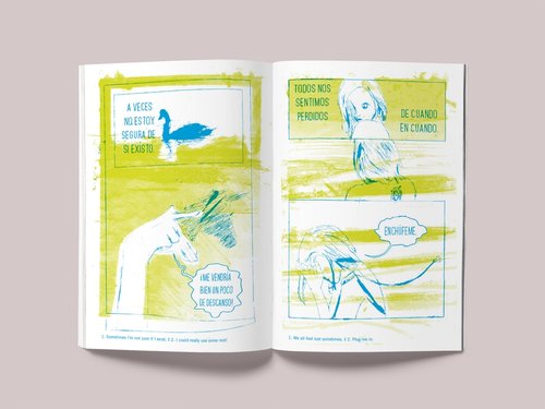 Spookytongue Revista aberta com ilustrações verdes e azuis e texto em português europeu sobre fundo branco