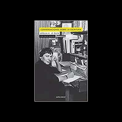 Capa de livro com fotografia preto e branco de mulher numa mesa de trabalho e texto em amarelo e branco