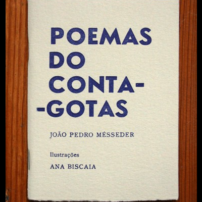 Capa de livro branco com texto azul e preto, sobre mesa de madeira marrom.