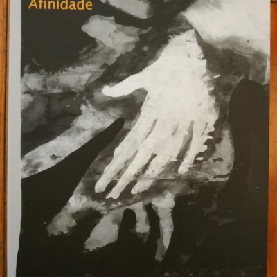 Capa de livro com título Símbolo, Analogia e Afinidade e imagem de duas mãos sobrepostas em tons de cinza