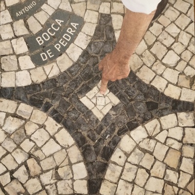 Capa do livro 'Bocca de Pedra' com padrão de calçada portuguesa e mão a tocar pedra