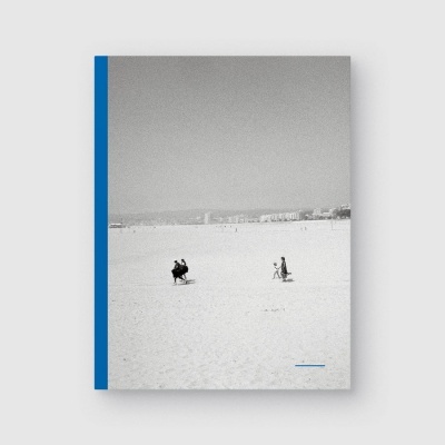 Livro com capa foto de praia a preto e branco e faixa azul na lateral