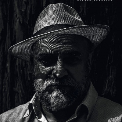 Capa de livro 'O LONGO PEIDO DA SEQUÓIA' com homem de chapéu de palha e barba