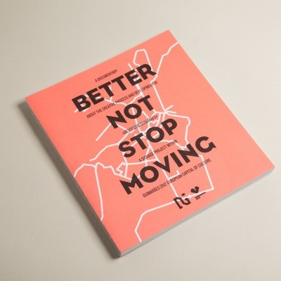 Livro com capa cor de salmão e texto preto BETTER NOT STOP MOVING