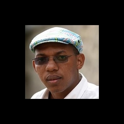 Homem com chapéu boina colorido e óculos escuros