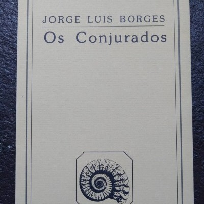 Capa de livro creme com texto preto e desenho de fóssil em espiral.