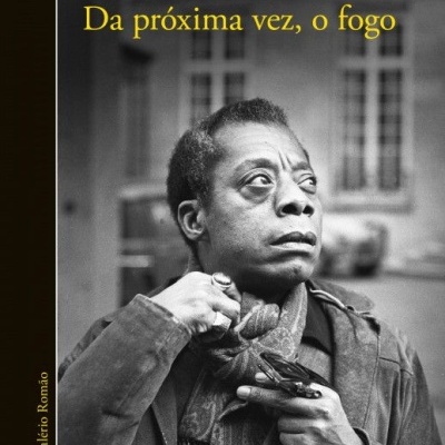 Capa de livro 'Da próxima vez, o fogo' de James Baldwin com fotografia a preto e branco de homem e textos em amarelo