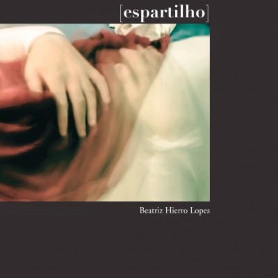 Capa de livro com imagem desfocada de mãos segurando tecido, título '[espartilho]'