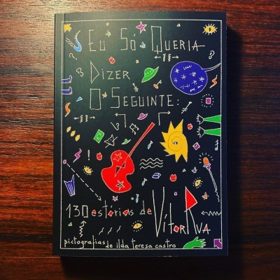 Capa de livro preto com ilustrações coloridas e título em letras desenhadas