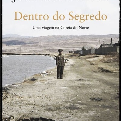 Capa de livro 'Dentro do Segredo' com soldado numa estrada ao lado de um rio e texto de autoria e subtítulo.
