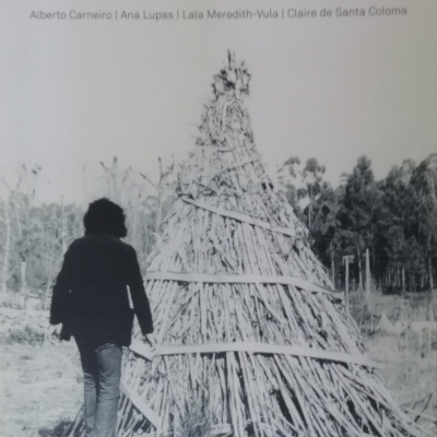 Capa de livro sobre topografias rurais com estrutura cónica de madeira e pessoa de costas.