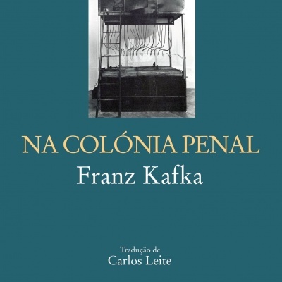 Capa do livro 'NA COLÓNIA PENAL' com imagem de estrutura metálica preta e branca