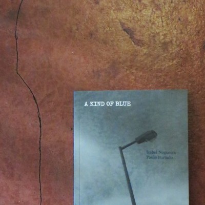 Livro 'A KIND OF BLUE' sobre superfície castanha com fissura