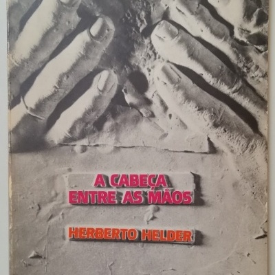 Capa de livro com mãos em relevo cinzentas e texto rosa e laranja