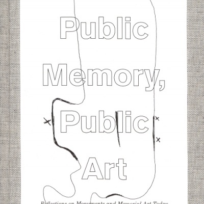 Capa de livro branca com título em letras grandes e texto pequeno, sobre superfície texturizada cinzenta