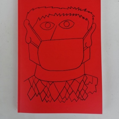 Caderno vermelho com ilustração a preto de pessoa com máscara