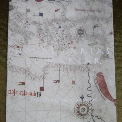 Livro com capa mostrando mapa antigo e texto em letras grandes sobre tecido verde.