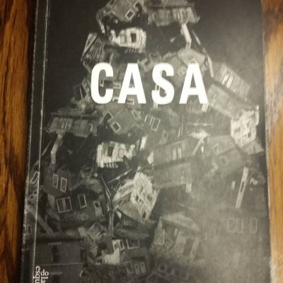 Capa de livro preta e branca com imagens de casas e título CASA