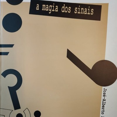 Capa do livro 'a magia dos sinais' com símbolos gráficos em preto sobre fundo bege e branco