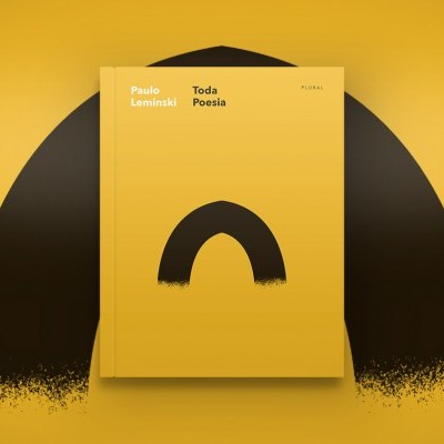 Livro amarelo 'Paulo Leminski - Toda Poesia' com pintura preta em fundo amarelo