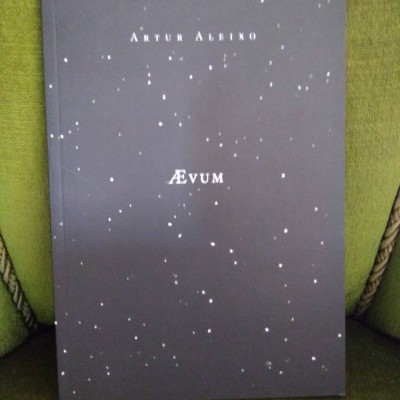 Livro preto com pontos brancos 'ÆVUM' de Artur Albino sobre cadeira verde