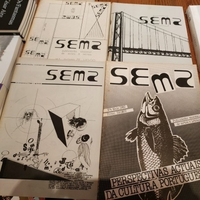 Publicações pretas e brancas com textos e ilustrações diversas sobre uma mesa