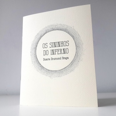 Livro branco com título e nome do autor dentro de um círculo pontilhado cinzento