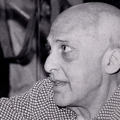 Homem calvo de camisa padronizada em preto e branco olhando para a esquerda