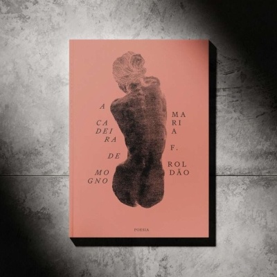 Capa de livro cor de rosa escura com desenho de figura humana e texto em letras pretas