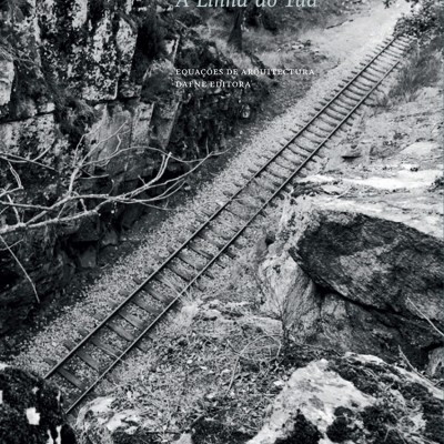 Capa de livro com trilhos de comboio entre rochas e vegetação