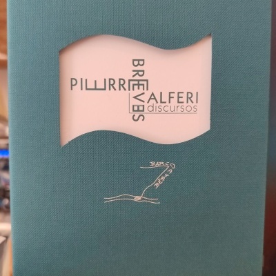 Livro com capa verde-azulada e recorte ondulado mostrando texto e desenho interno.