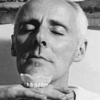 Homem com olhos fechados segurando molde de dentes