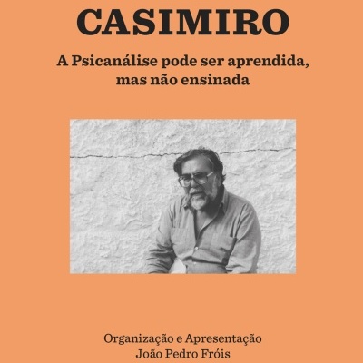 Capa de livro cor coral com texto preto e foto a preto e branco de homem de barba e óculos