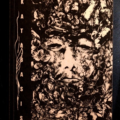 Capa de livro com rosto feminino em padrões de pedra e o título 'KATABASIS' na vertical