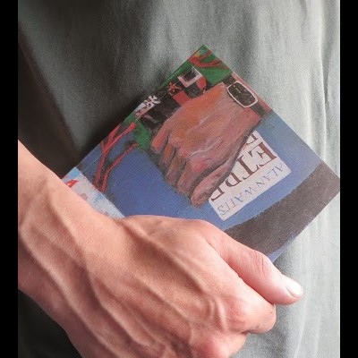 Pessoa a segurar livro colorido com título 'ALLEN WAITS' e 'FIDE'