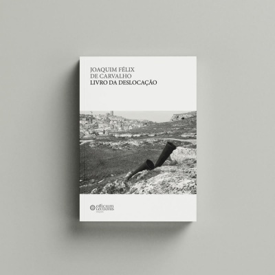 capa do livro 'Livro da Deslocação' com fotografia a preto e branco de uma paisagem rochosa e uma cidade ao fundo