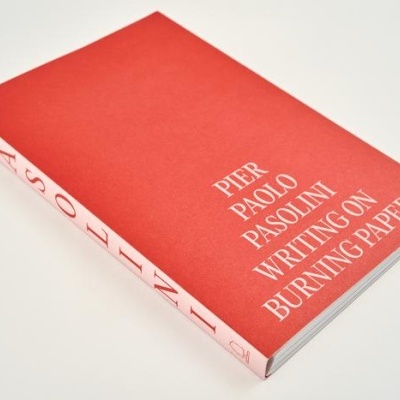 Livro com capa vermelha intitulado 'Pier Paolo Pasolini Writing on Burning Paper'