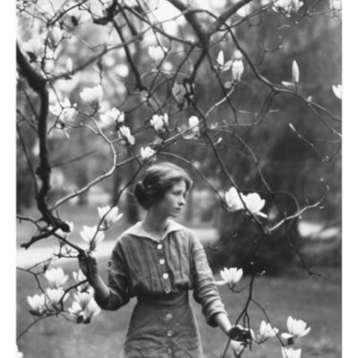 Mulher jovem em jardim com ramo florido