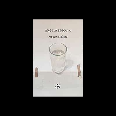 Livro com título 'Mi paese salvaje' e copo de água transparente em fundo branco