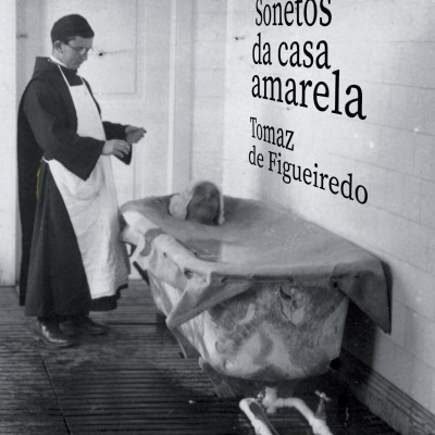 Homem com bata ao lado de banheira antiga com pessoa deitada, texto na parede