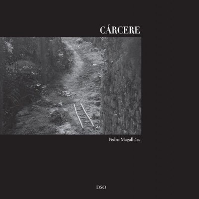 Capa de livro preta com fotografia a preto e branco de um caminho estreito entre muros de pedra e uma pequena escada de madeira