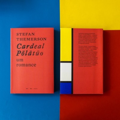 Dois livros vermelhos sobre superfície colorida azul, amarelo, branco e vermelho