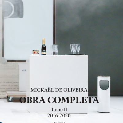 Capa de livro com caixa branca, garrafa de champanhe e copos, espelho e parede cinza