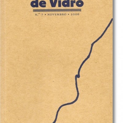 Capa de revista Telhados de Vidro castanha com texto azul e linha ondulada azul