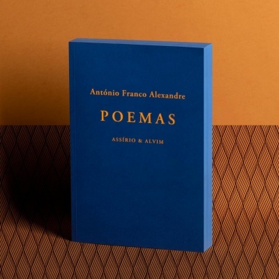 Livro 'POEMAS' de António Franco Alexandre com capa azul sobre fundo castanho claro