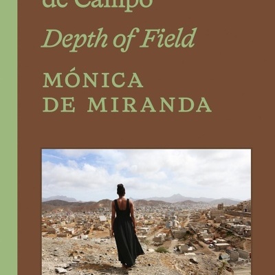 Capa de livro com texto e foto de mulher em vestido preto de costas numa cidade árida