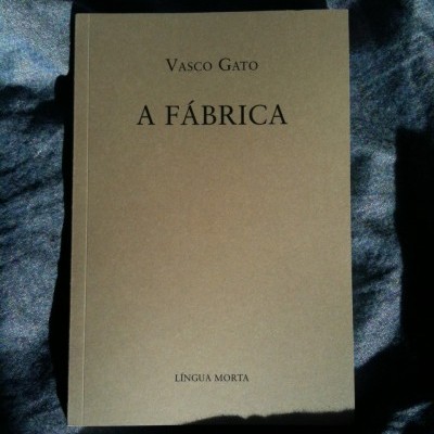 Livro 'A Fábrica' de Vasco Gato sobre tecido azul escuro