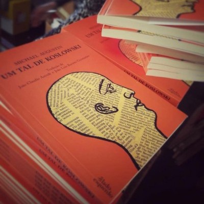 Livros com capa laranja e desenho de cabeça humana com texto impresso