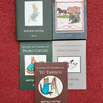 Cinco livros de Beatrix Potter sobre carpete vermelha